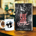 Paperback book "She Gives Love a Bad Name" with a black-and-white cover featuring a close-up of a couple about to kiss with red and white lettering.